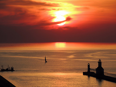 sailing boat on ocean water during sunset thumbnail