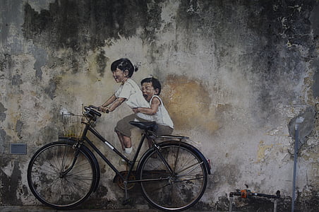 two children riding black city bike thumbnail