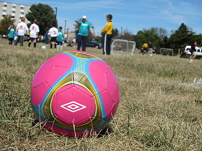 shallow focus of pink and blue soccer ball on field thumbnail