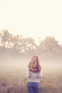 woman wearing sweatshirt standing near trees thumbnail