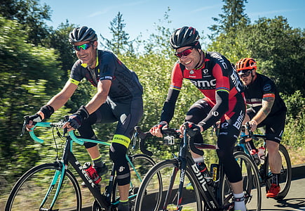 three men riding road bikes on street thumbnail
