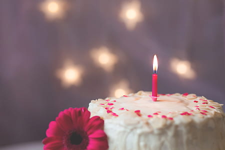 pink candle on white icing cake thumbnail