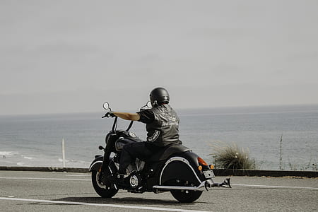 man riding chopper motorcycle on seaside asphalt road thumbnail