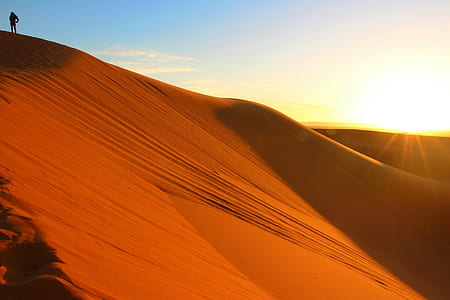 person standing on top of desert mountain during daytime thumbnail