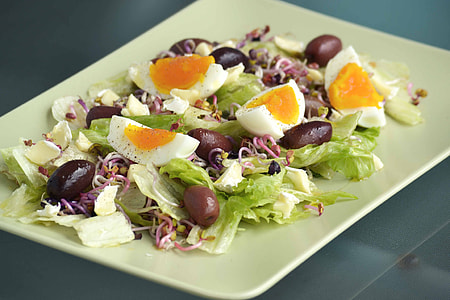 rectangular white plate with vegetable salad topped with sliced hard boiled egg thumbnail