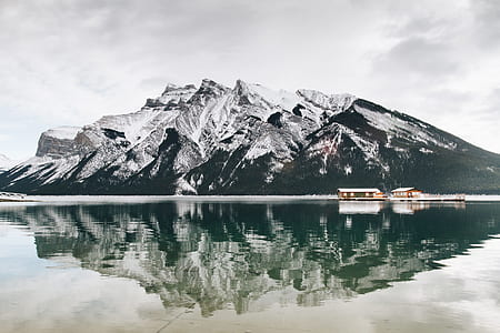 boat sailing on body of water in distance of mountain thumbnail