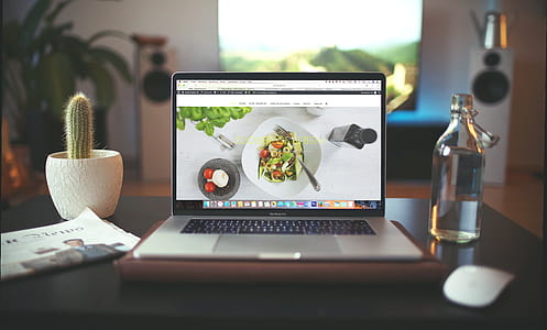 MacBook Pro beside clear glass bottle thumbnail