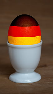 brown, red, and yellow painted egg on cup thumbnail