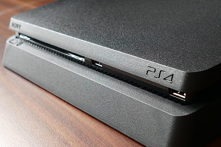black Sony PS4 slim on brown surface thumbnail