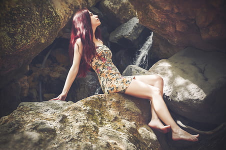 woman wearing white floral dress sitting on gray rock thumbnail