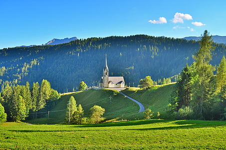 white concrete church on top of hills surrounded by trees at daytime thumbnail