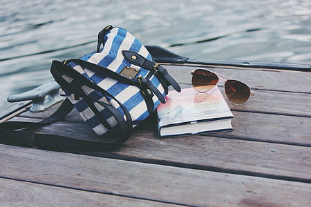 brown sunglasses on top of book thumbnail