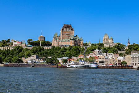 city buildings near body of water under blue sky thumbnail