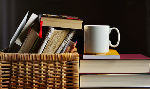 white ceramic mug beside books in brown wicker basket thumbnail