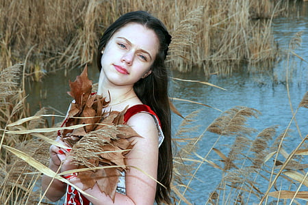 closeup photo of woman holding dried leaves thumbnail