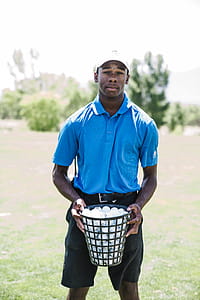 Man Holding Basket of Golf Balls thumbnail