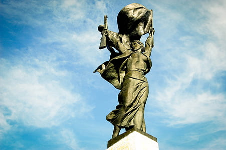 low-angle photography of woman holding rifle statue thumbnail