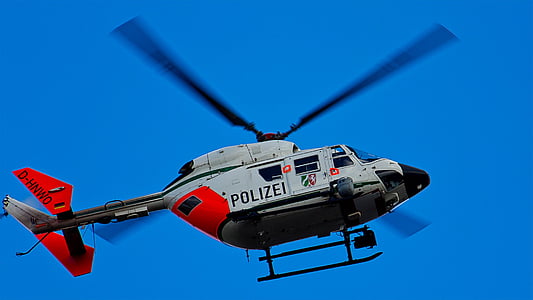 flying white and red helicopter under blue sky thumbnail