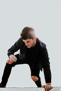 man leaning on the floor during daytime thumbnail