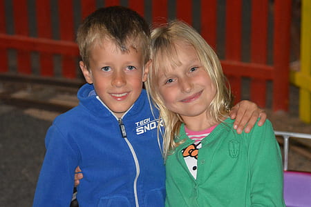 boy and girl taking photo near red fence thumbnail