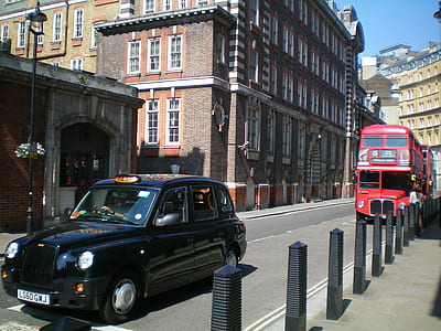 red double deck bus parked beside building thumbnail