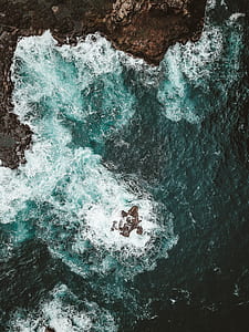 brown rock formation near body of water thumbnail