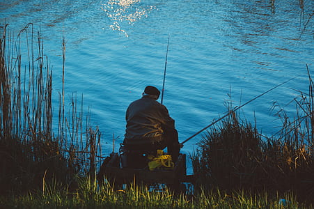 Man Sitting on the Chair While Doing Fishing Near Body of Water thumbnail