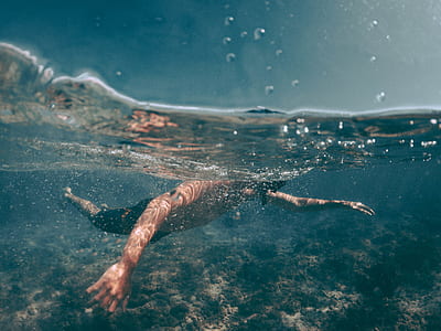man swimming on clear water thumbnail