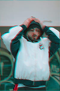 man in white and black FILA jacket holding head thumbnail