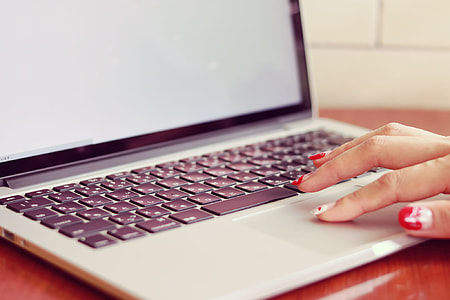 woman with pink manicure touching the laptop in a well lit room thumbnail