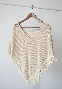 beige knitted poncho with clothes hanger thumbnail