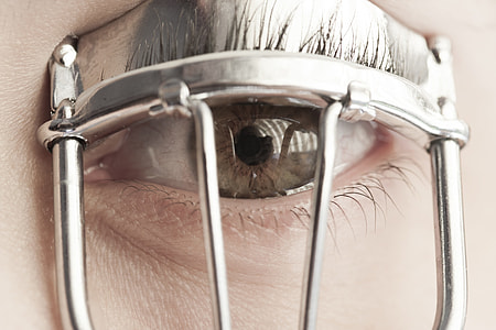 selective focus photography of person using gray stainless steel eyelash curler thumbnail