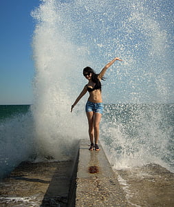 woman standing on breakwater during daytime thumbnail