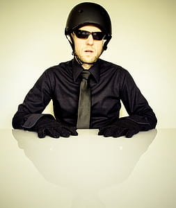man wearing black bicycle helmet and black dress shirt in front of table thumbnail