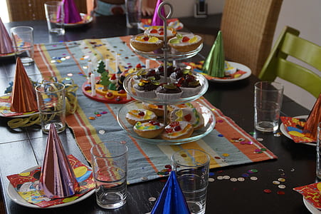 assorted-flavor cupcakes on 3-tier rack and party cones on plates thumbnail