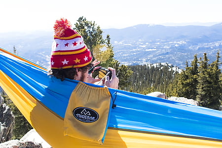 man on hammock taking photo thumbnail