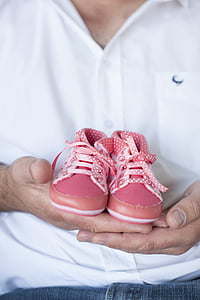 person holding pair of pink sneakers thumbnail