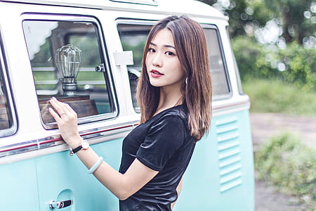 woman in black t-shirt near teal car thumbnail