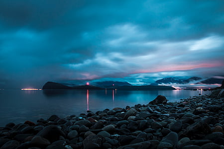 rocky shore beside wide body of water thumbnail