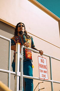 man holding metal fence near pink building thumbnail