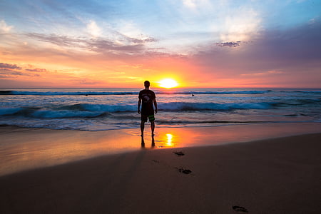 silhouette of man facing seashore thumbnail