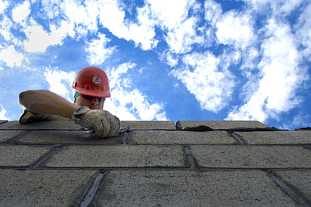 man in red hard hat on top of cinder block thumbnail