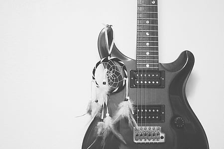 grayscale photo of stratocaster electric guitar with dreamcatcher thumbnail