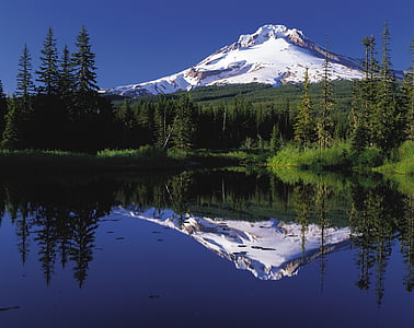 snow covered mountain near body of water during daytime thumbnail