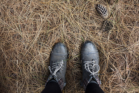 person wearing pair of gray leather cap-toe combat boots standing on hay thumbnail