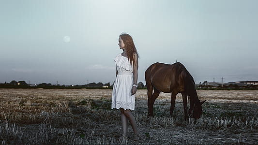 woman standing near brown horse thumbnail