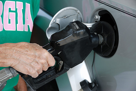 person holding black gas nozzle thumbnail