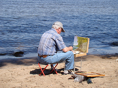 man in blue jeans painting near body of wate thumbnail