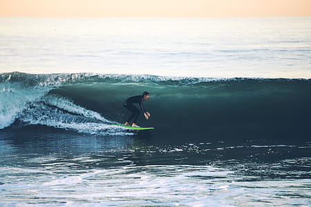 man riding green surfboard thumbnail