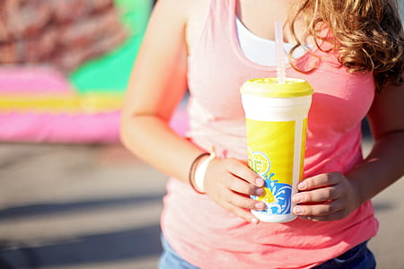 Woman Wearing Pink Tank Top Holding A Tumbler thumbnail